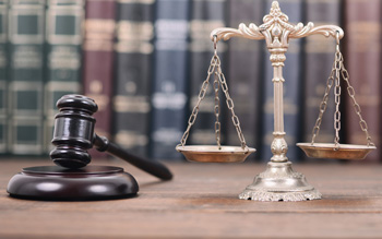 gavel and scales in front of row of books