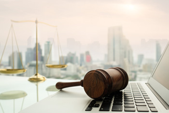 gavel and computer with skyscrapers in the background