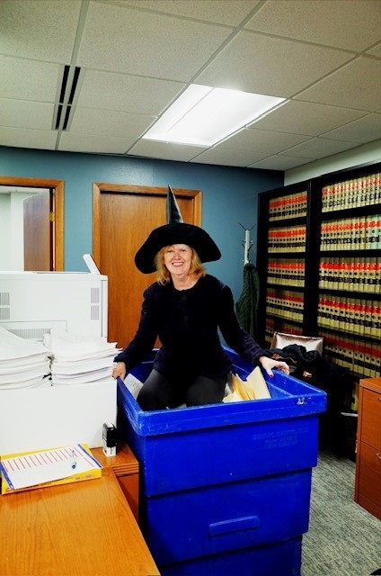 Nancy Kopp embraces tradition by climbing into a recycling bin during her annual office file purge